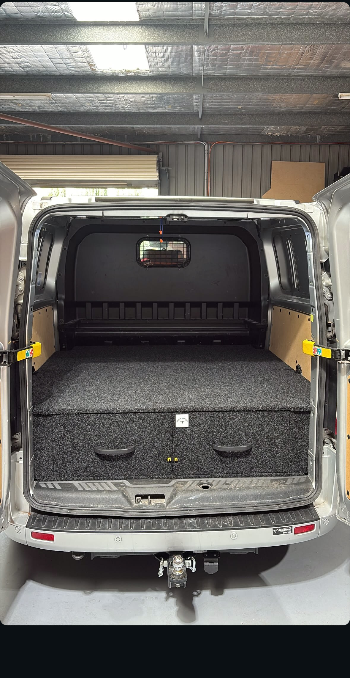 Silver work van with twin drawers and a carpeted false floor, rear doors open